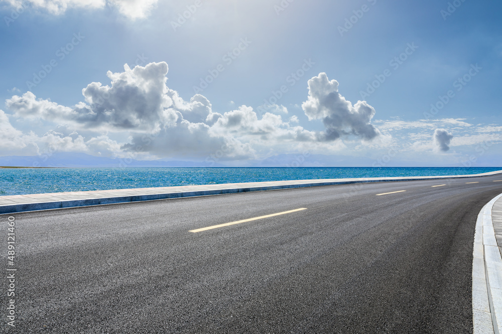 Asphalt road and sea natural scenery under blue sky