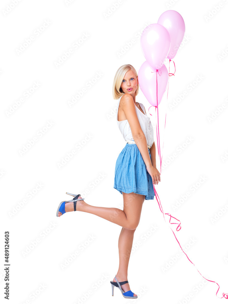 Sassy and cute. Flirtatious young woman popping her foot and holding a bunch of pink balloons.