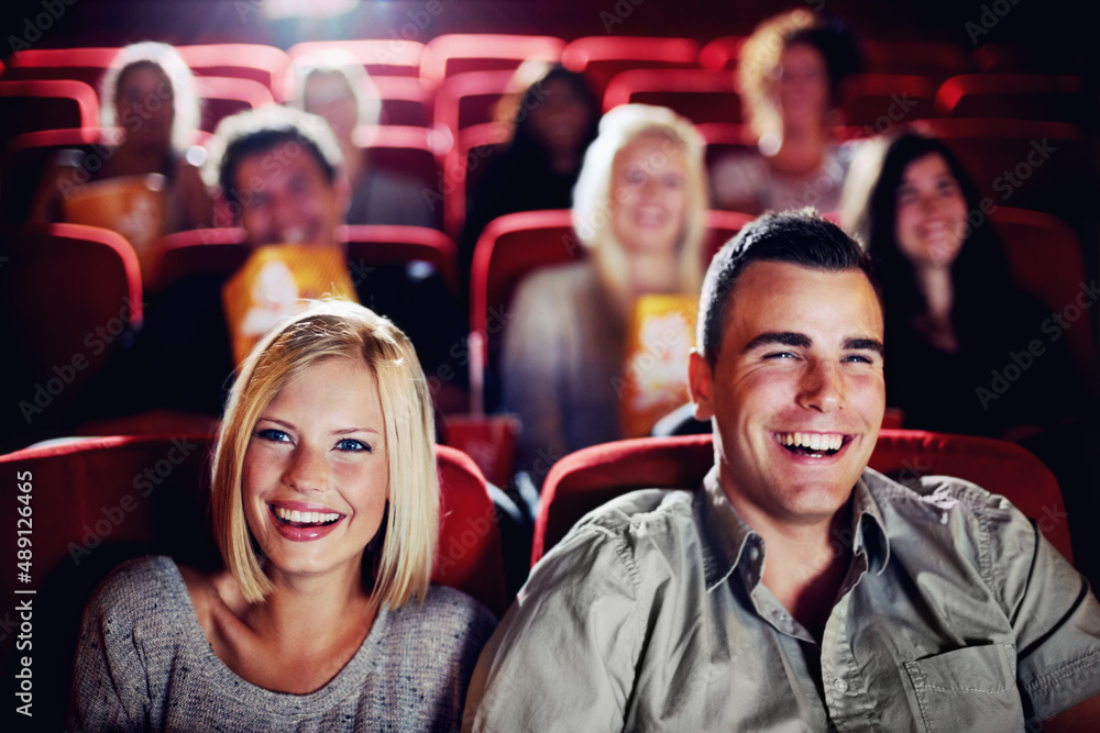 Enjoying a great comedy. A couple laughing and watching a movie together at the cinema.