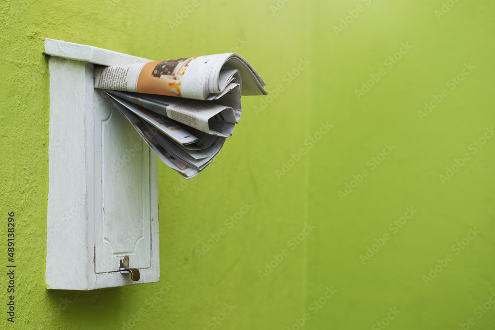 The latest paper delivered straight to your mailbox. Cropped shot of newspapers in a letter box.