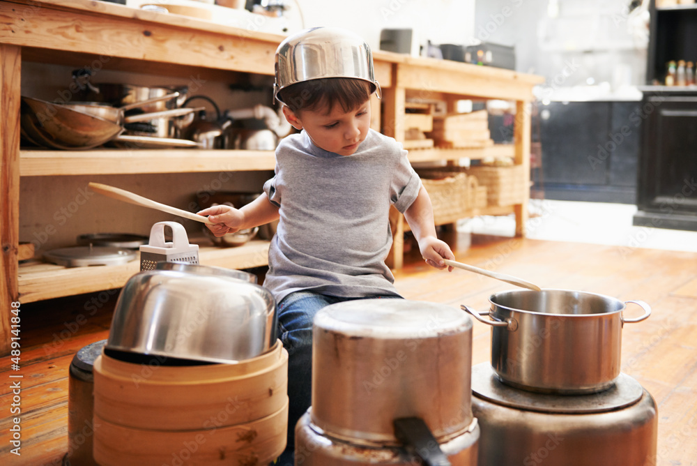 Rock star in the making. A young boy playing drums on pots and pans.