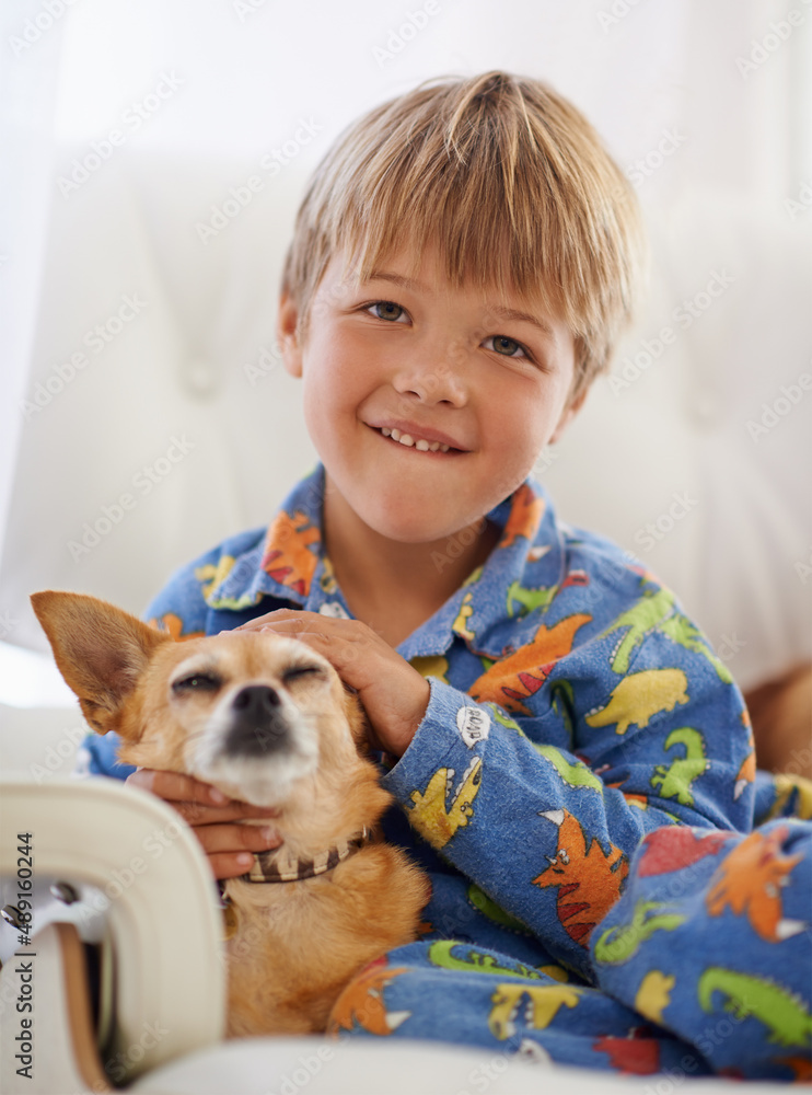 Snuggling his old friend. A cute little boy cuddling his dog on the couch.