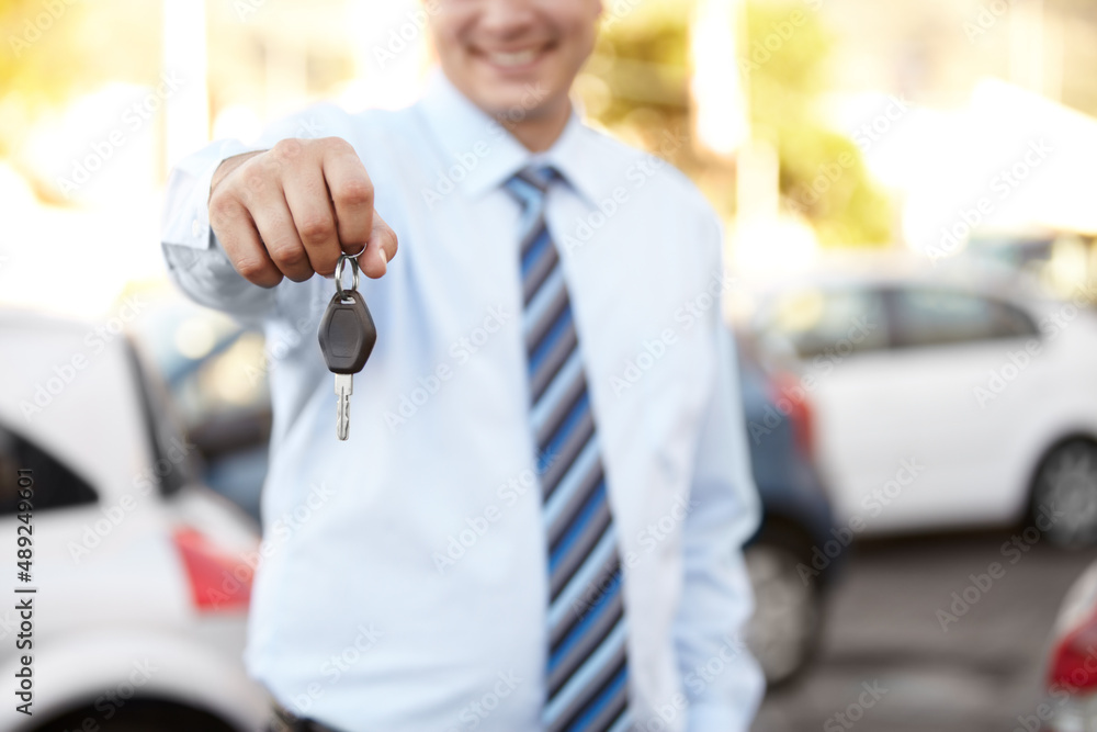 Your brand new car awaits. Cropped image a mans hand handing you a car key.