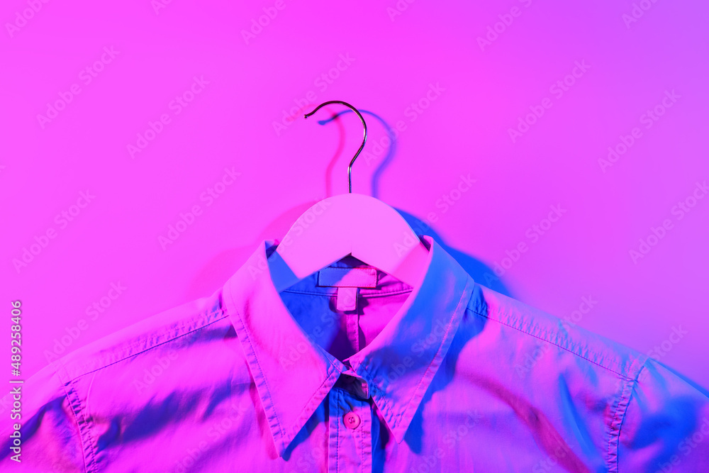 Clothes hanger with shirt on dark color background