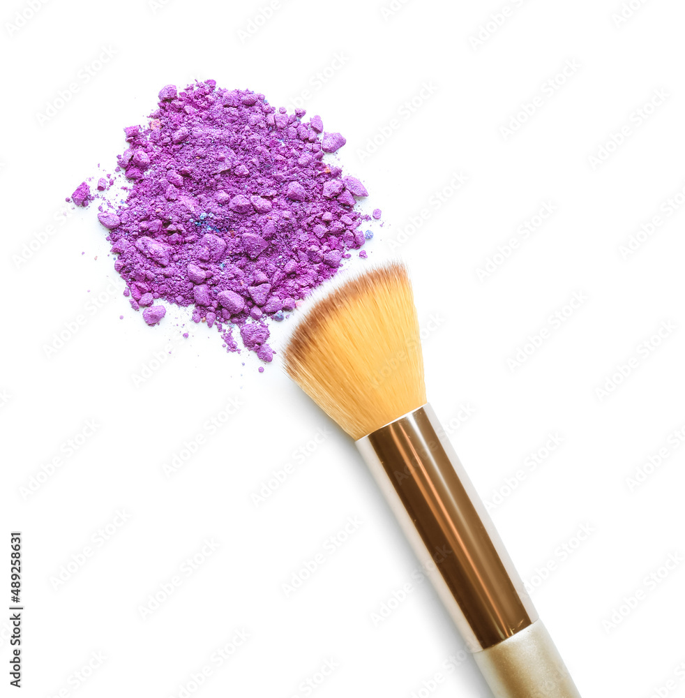 Makeup brush and loose eye shadow on white background