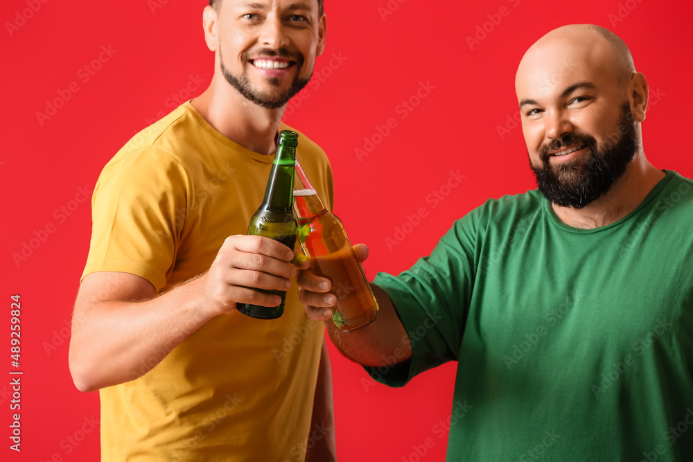 Men drinking beer on red background