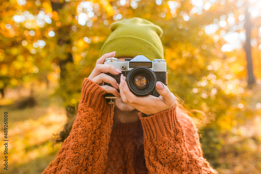 Woman taking picture in autumn forest