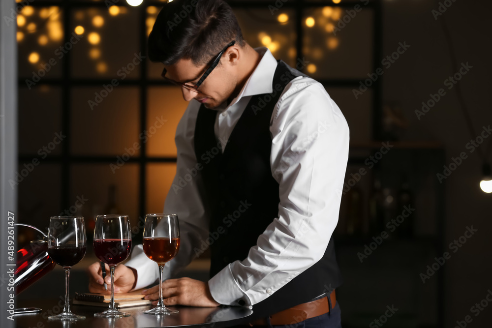 Young male sommelier tasting types of wine