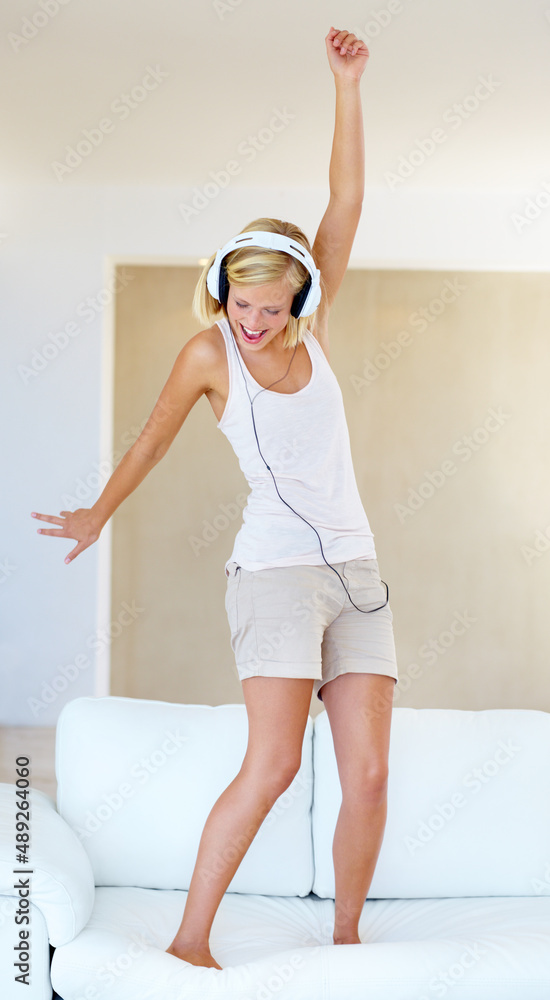 Dancing to the sound. A young woman dancing around while listening to songs on her headphones.