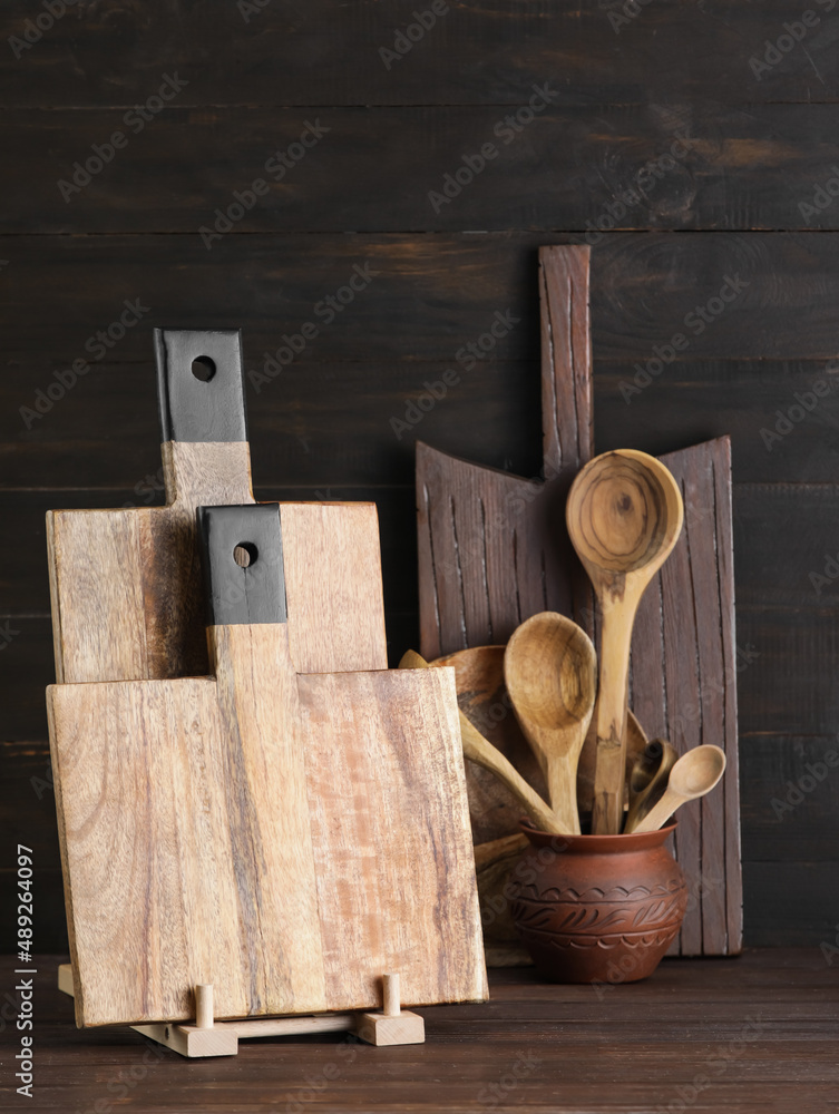 Cutting boards and spoons on dark wooden background