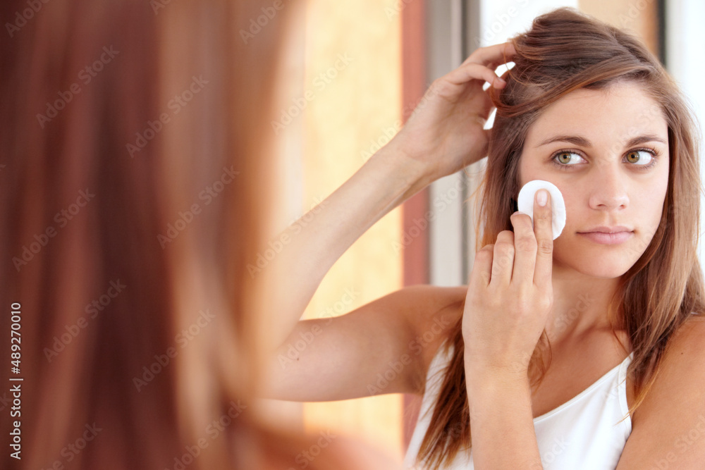 Exfoliation. A beautiful young woman cleaning her face.