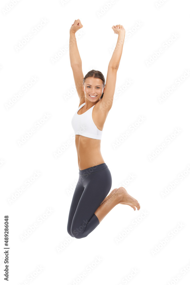 Jumping for the joy of exercise. A young woman in sportswear jumping against a white background.