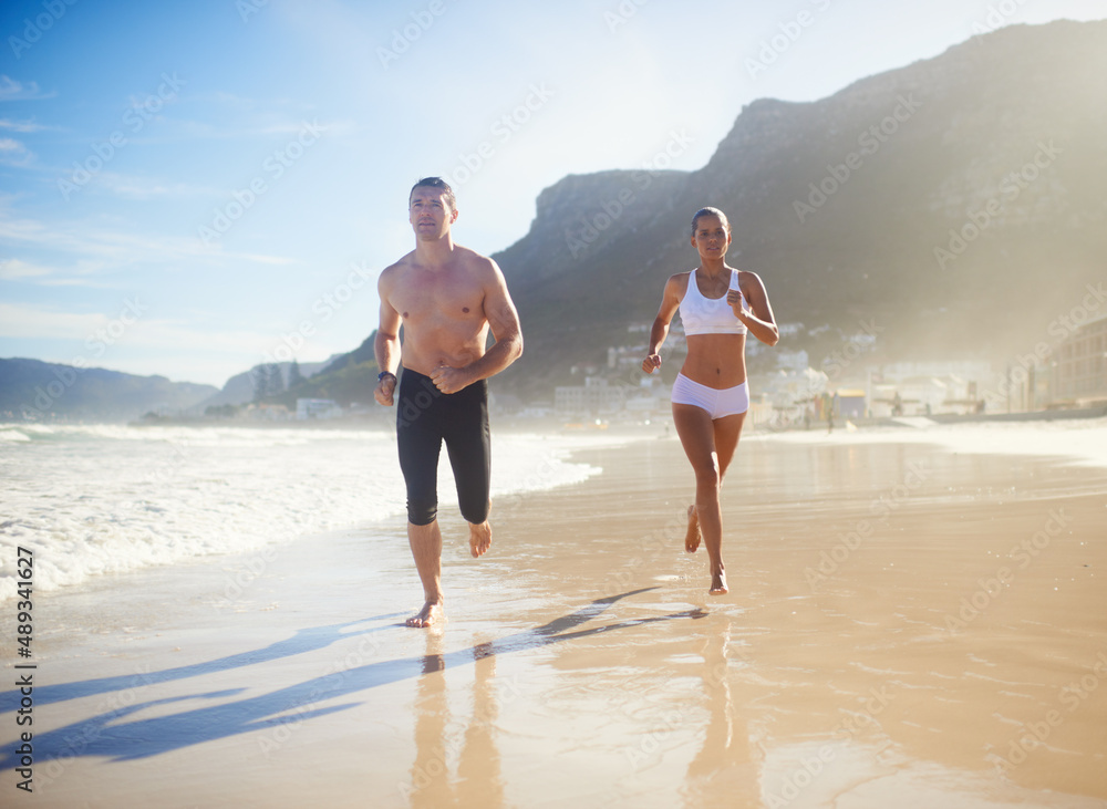 Getting her jog on. Full length shot of a couple running along the beach.