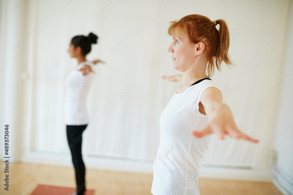 The perfect exercise to relieve stress. Shot of two women doing yoga together indoors.