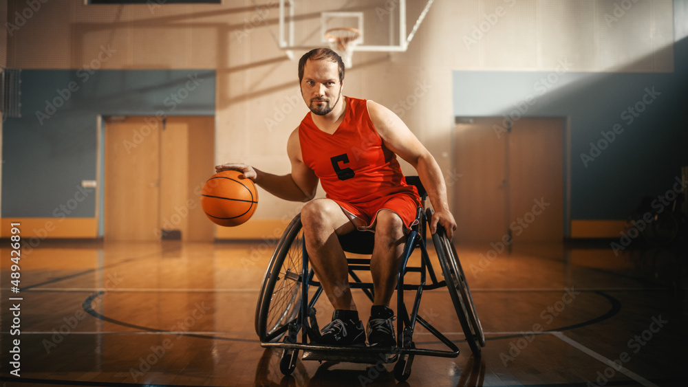 Portrait of Handsome Wheelchair Basketball Player Wearing Red Shirt Dribbling Ball, Looking at Camer