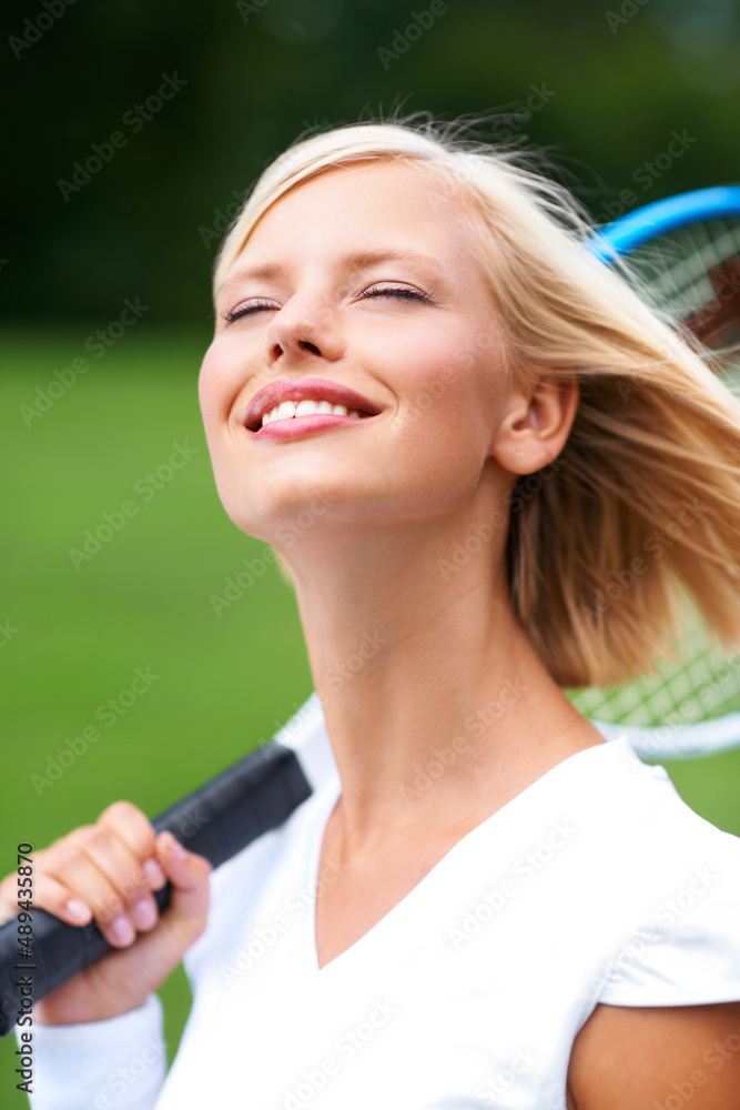 Enjoying the feel of the fresh air in her hair. A young tennis player with the wind in her hair and 