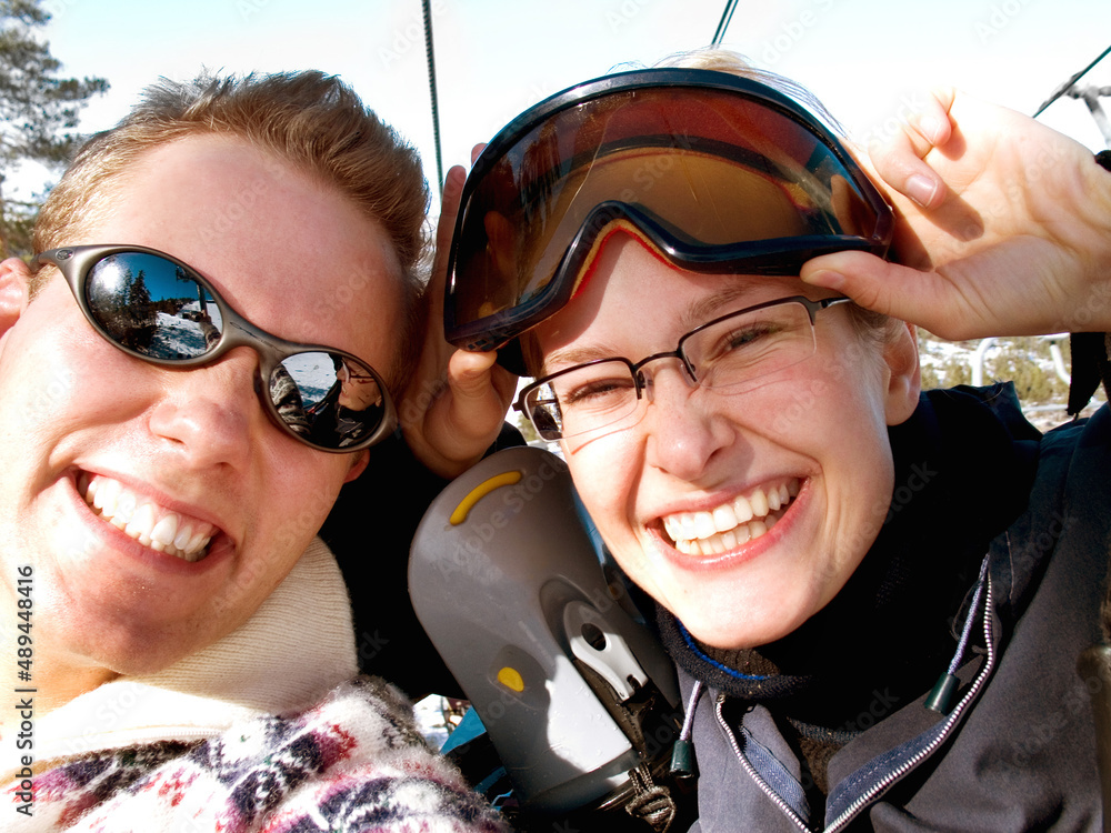 Winter vacations and recreation. A happy young couple about to go up a ski lift.