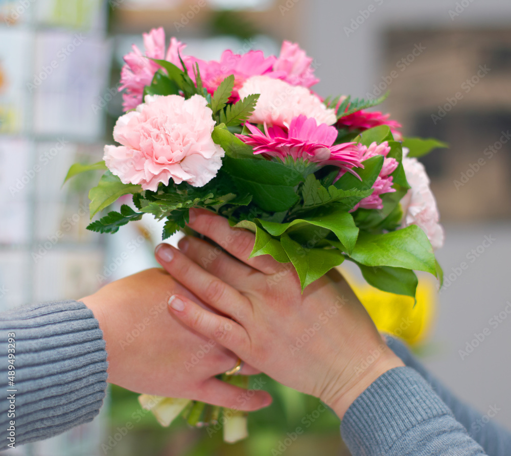 Thanks a bunch. Cropped shot of a bunch of flowers being handed to someone.