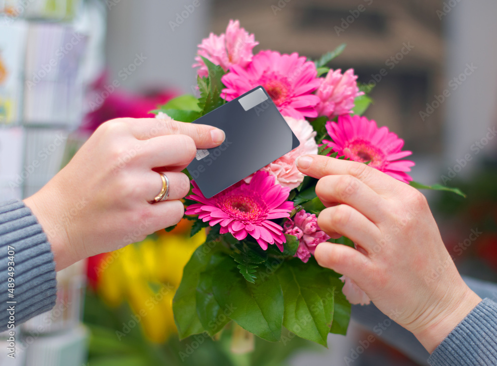 Proving that beauty can be bought. Cropped shot of a woman buying flowers with her credit card from 