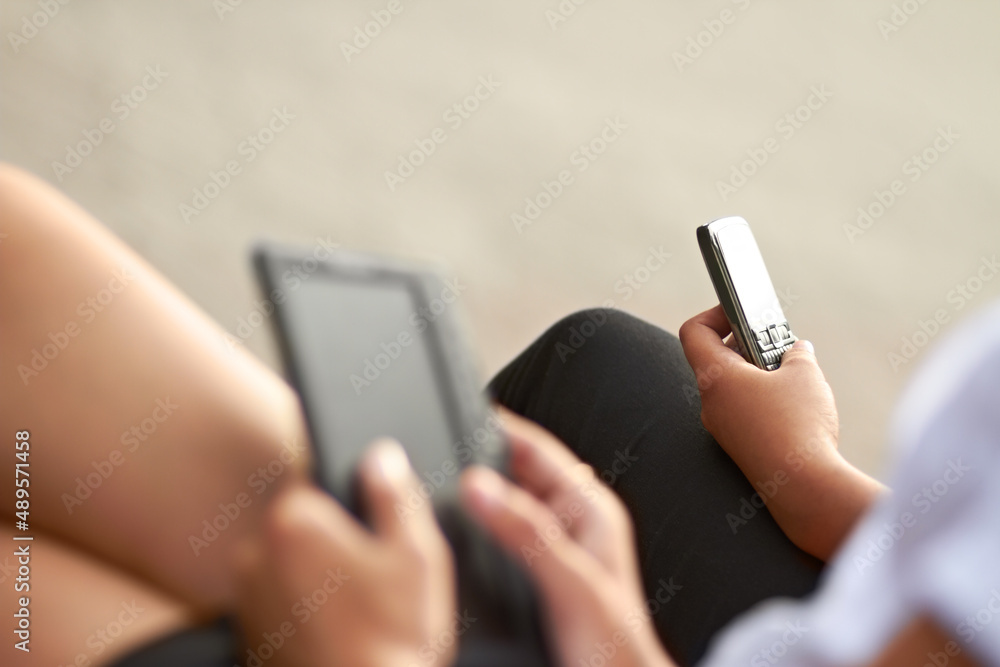 Modern technology. Cropped image of two students, one with a digital tablet and one with a cellphone