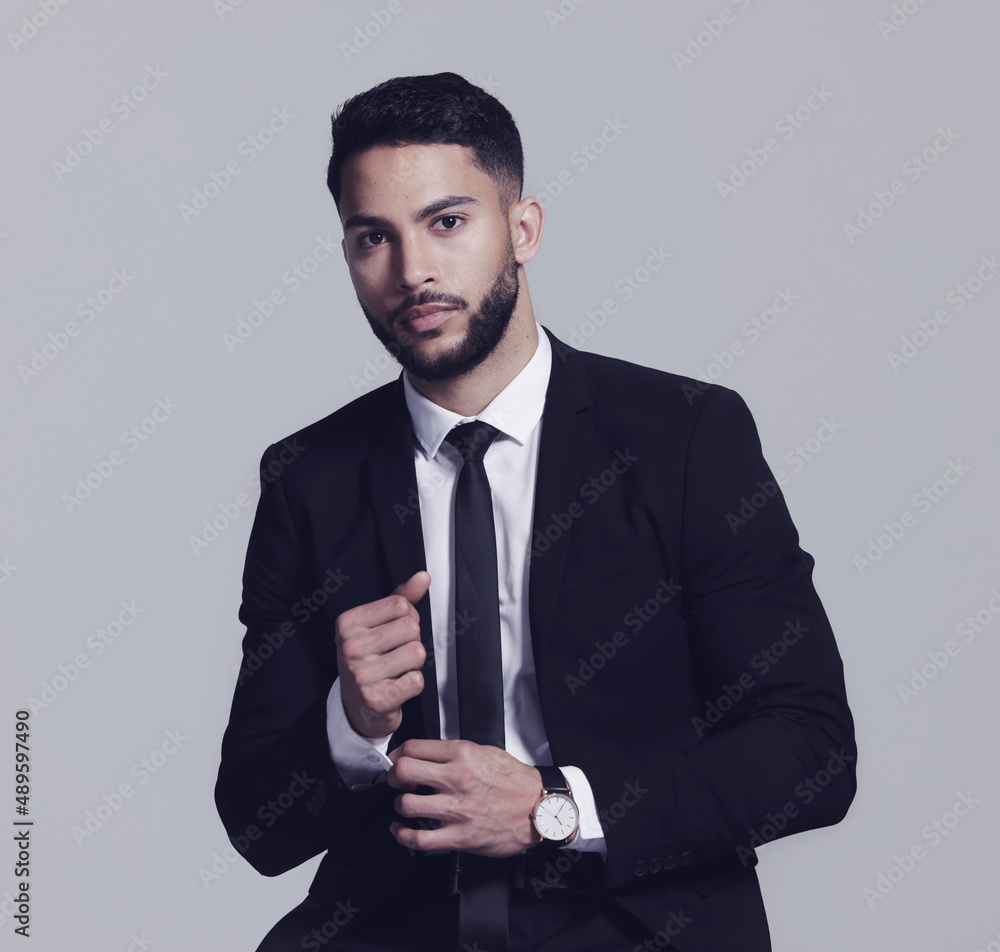 Hes all about business. Studio shot of a young man posing against a grey background.