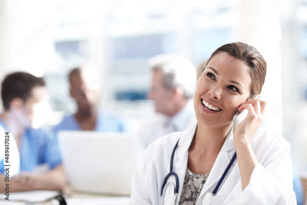 Good news for her patient. A beautiful medical professional talking on her cellphone with colleagues