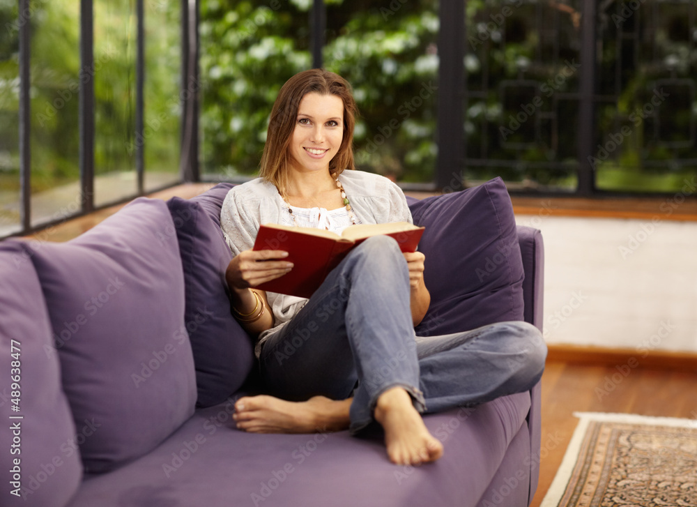 Reading relaxes me. Portrait of a beautiful woman reading on her sofa.