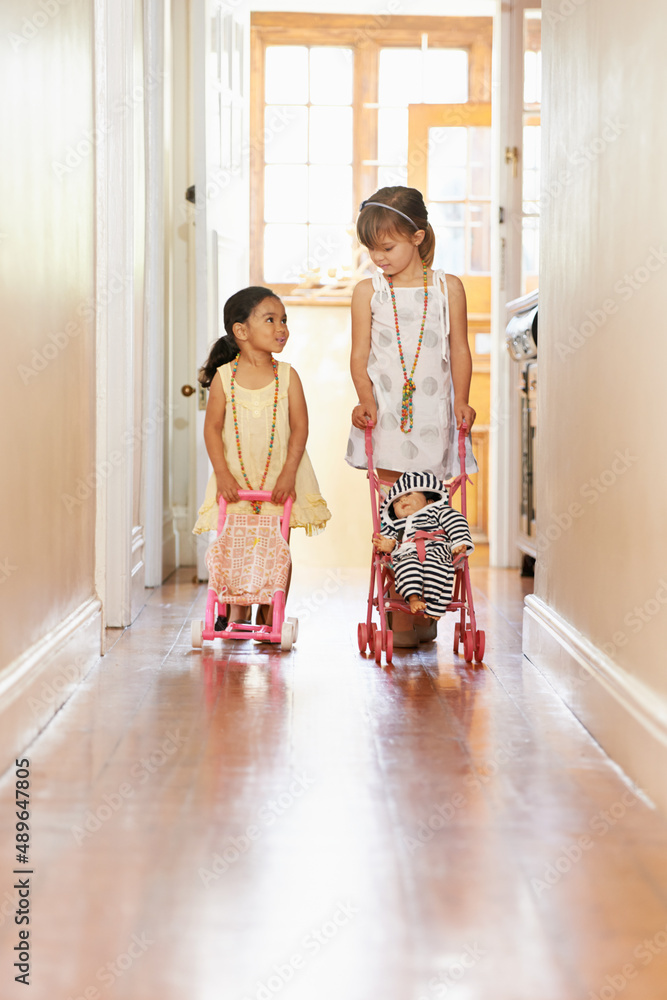 Acting like a mother..... Full-length shot of two little girls pushing prams.