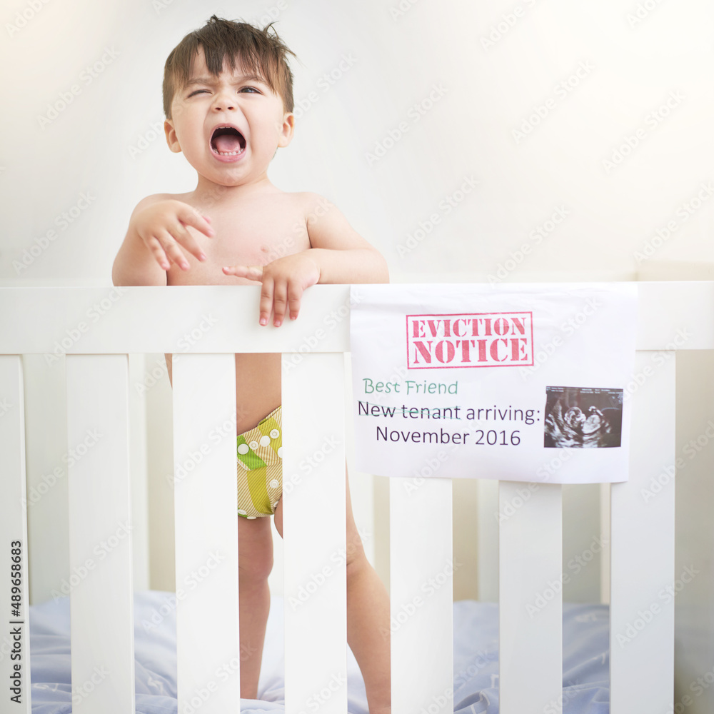 Dont I get a say. Shot of an unhappy baby boy crying while standing in his crib.