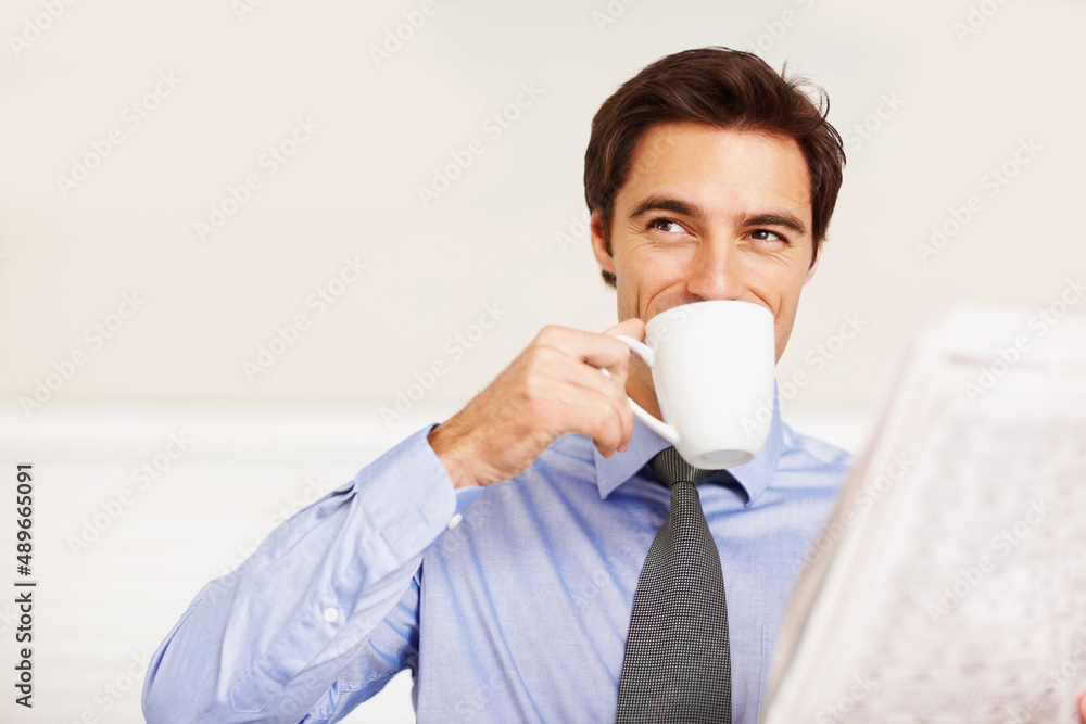 Young executive drinking coffee while looking away. Young business executive drinking coffee while l