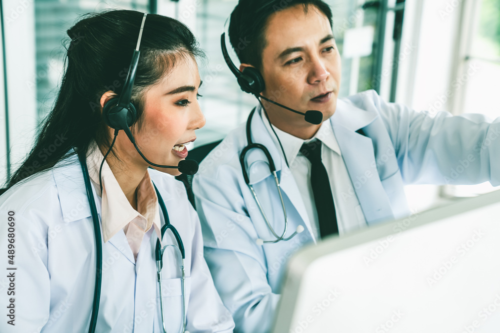 Doctor team wearing headset talking actively on video call in hospital clinic . Concept of telehealt