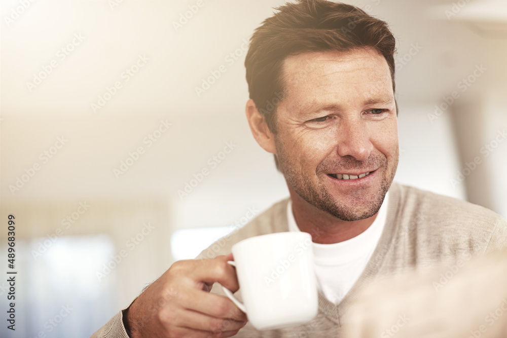 Getting his day off the perfect start. Cropped shot of a man drinking coffee while reading the paper