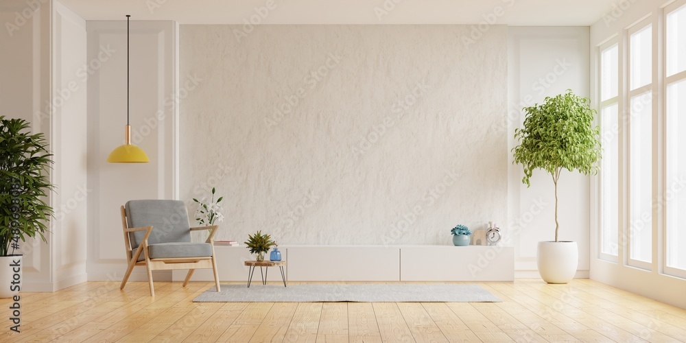 Cabinet for TV on the white plaster wall in living room with armchair,minimal design.