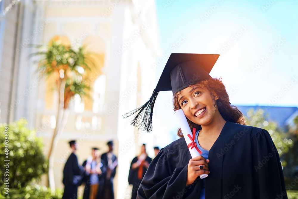 我不能为自己感到骄傲。一个快乐的年轻女子拿着毕业证书的剪影