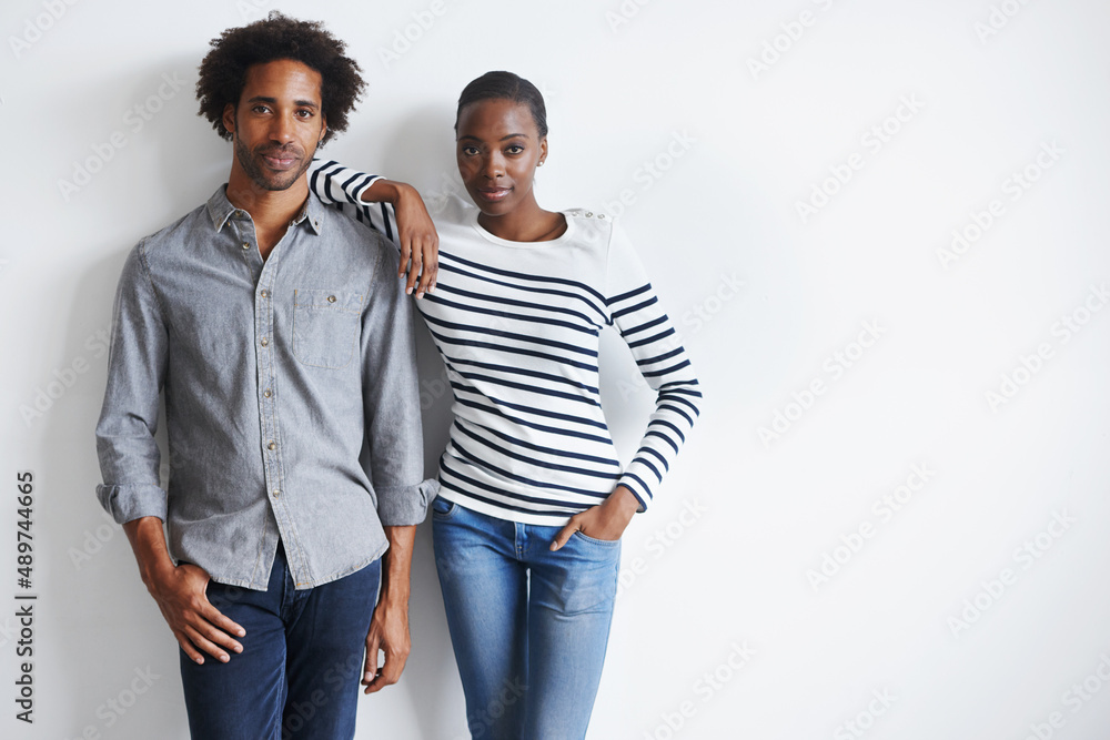 Simple and stylish. A portrait of a stylish young couple standing together affectionately against a 