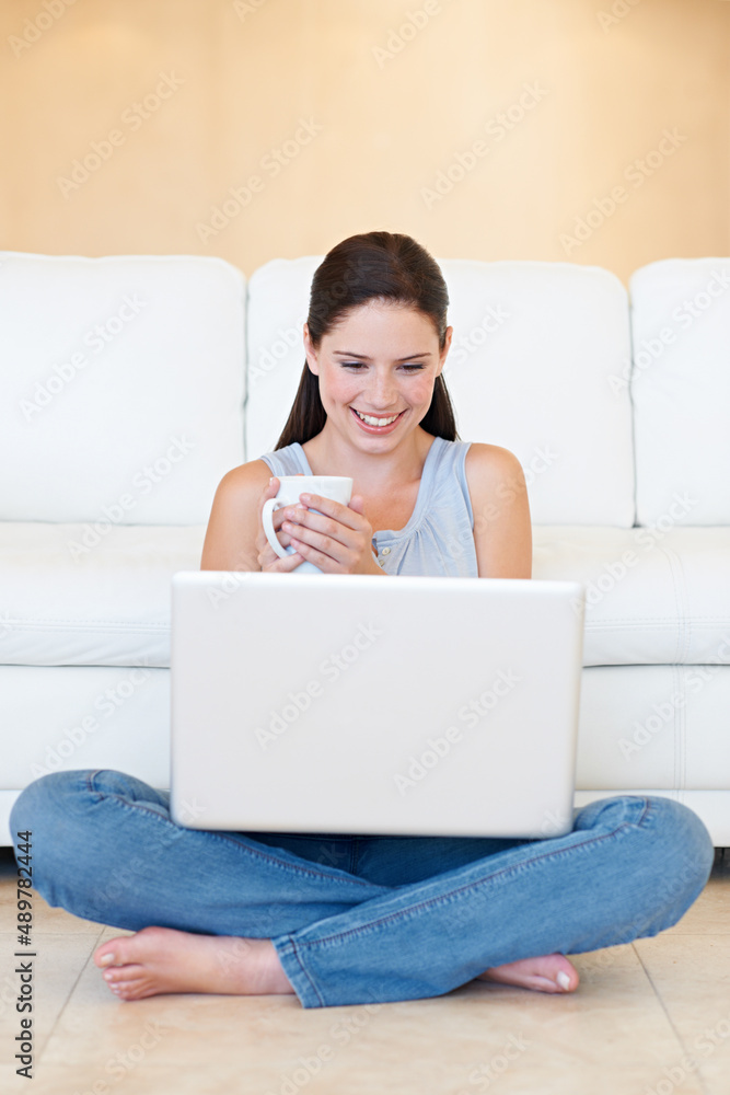 Coffee and a bit of social networking. A thoughtful young beauty with a laptop in her lap enjoying a