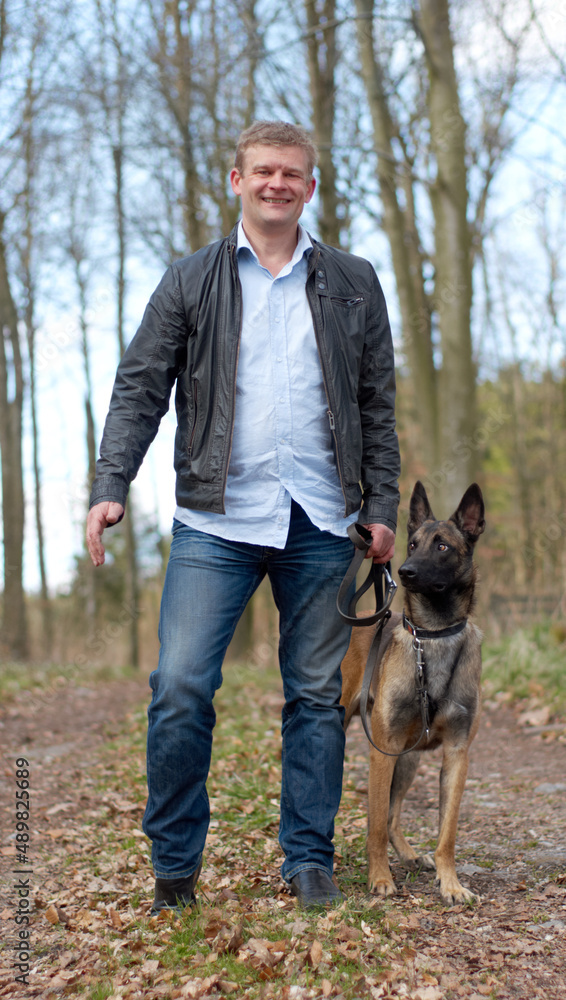 Out with my best friend. Shot of a man going for a walk with his dog in the woods.