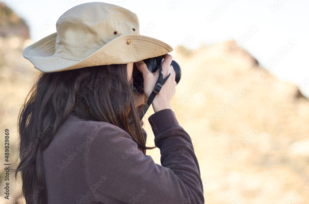 Capturing the wild. A young woman taking pictures outside.