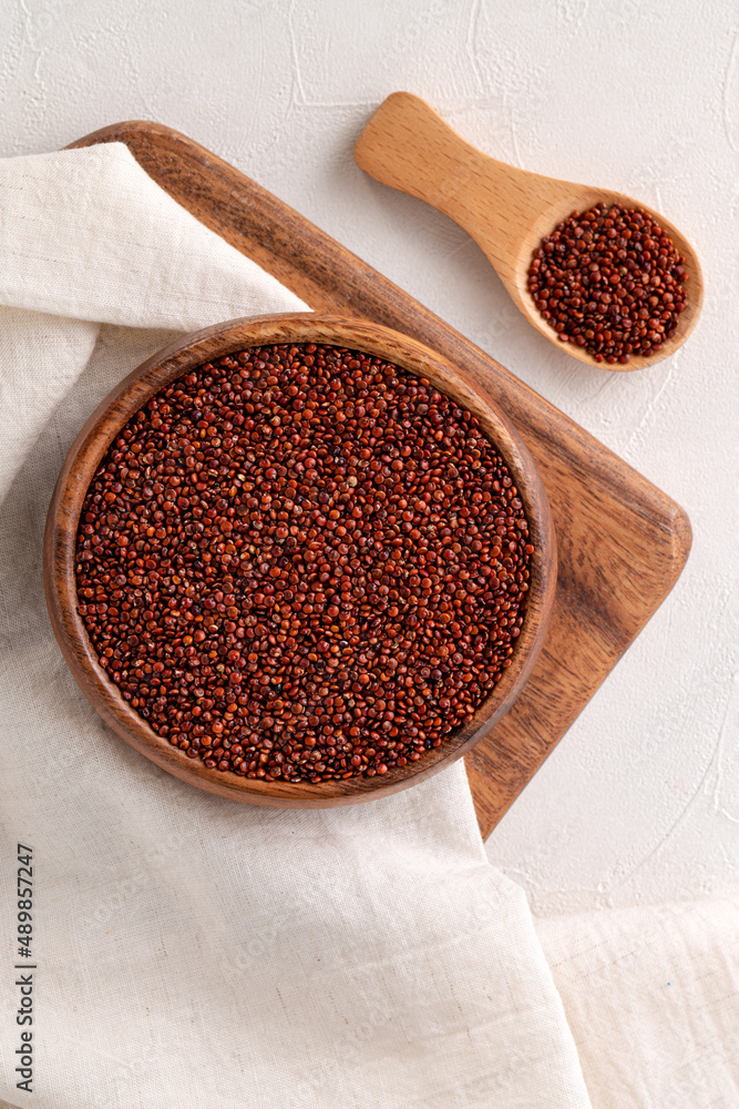 Organic red quinoa in a bowl on white table background.