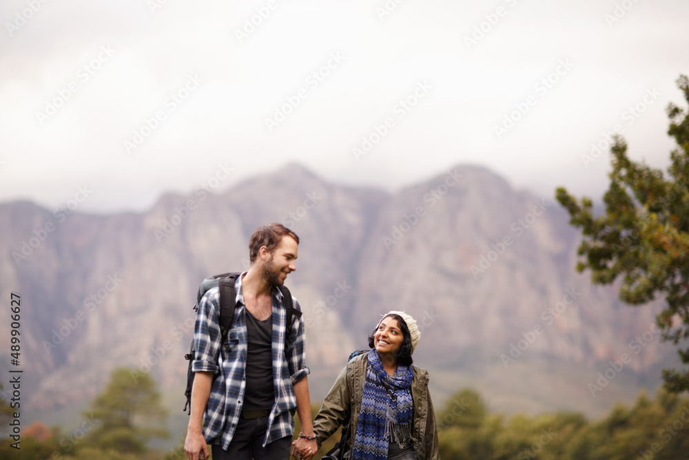 Enjoying a nature walk. Cute young couple exploring the outdoors together.