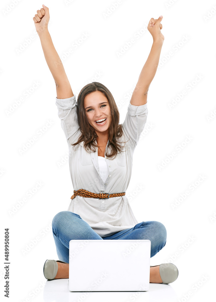 One thousand hits. Studio portrait of a young woman sitting in front of a laptop with her arms raise