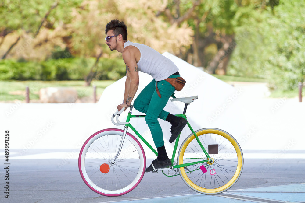 Bad ass biker. A handsome young man riding his bicycle outdoors.