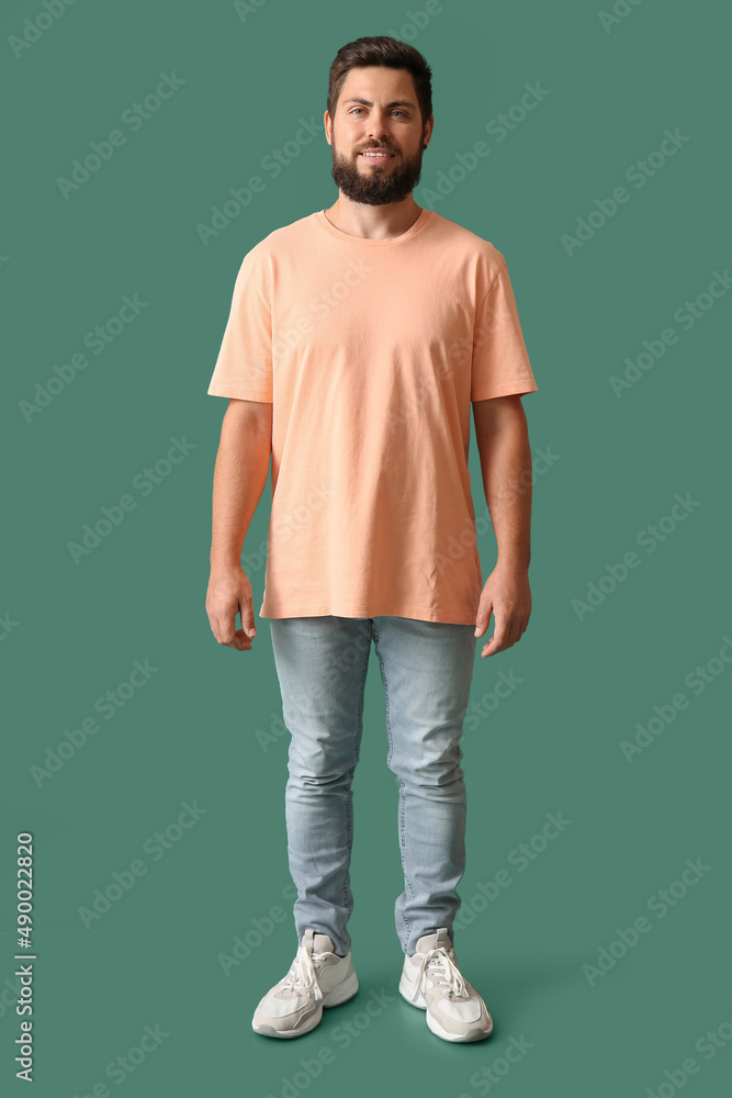 Handsome man in beige t-shirt on green background