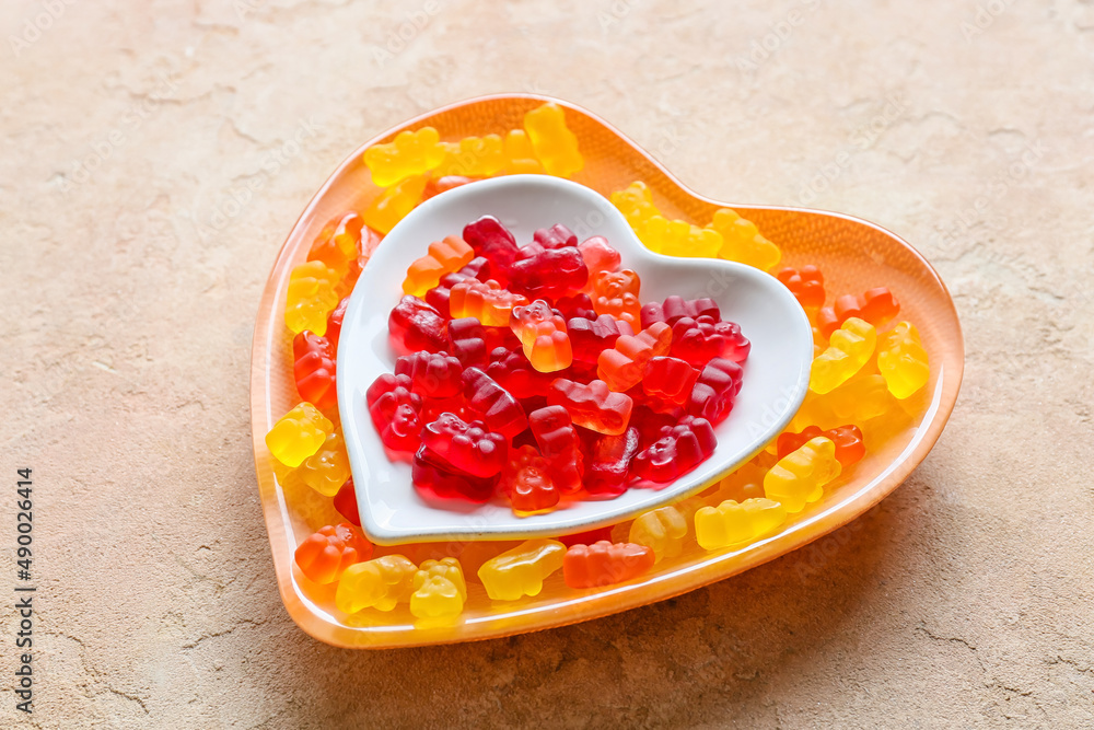 Plate with sweet jelly bears on light background