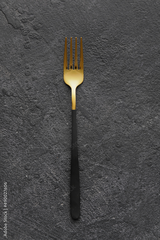 Stylish stainless steel fork on black background