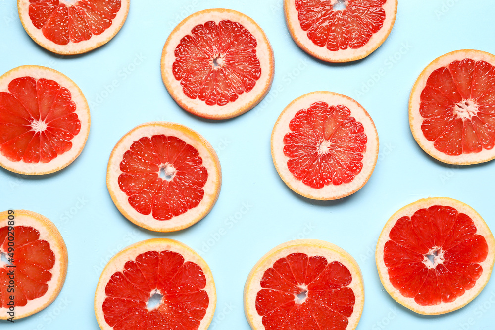 Slices of tasty ripe grapefruit on blue background