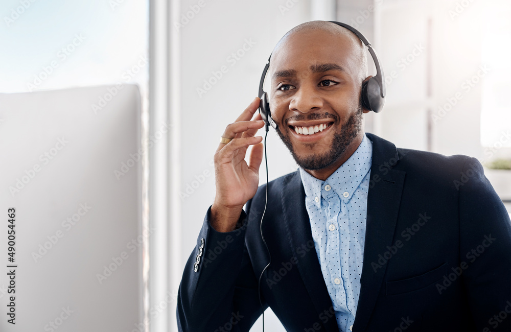 We have our best agent on the line. Cropped shot of a call centre agent sitting at his desk.