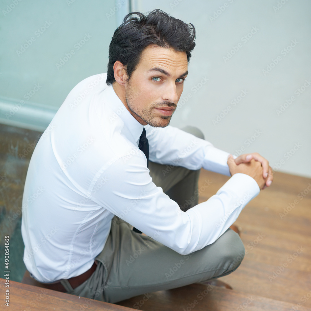 Down to earth businessman. A handsome young businessman sitting on a staircase.