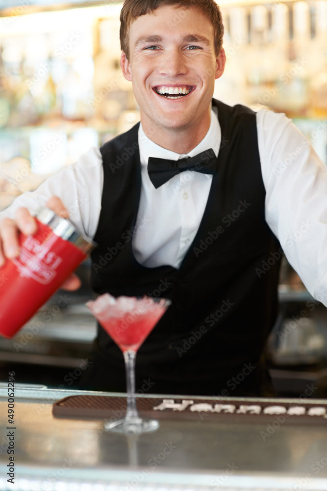 Quenching any ladys thirst. Young handsome barman laughing and smiling while wipping up a delicous a