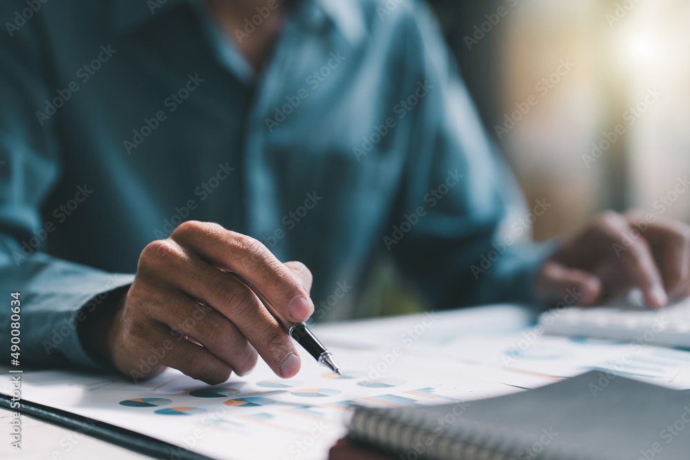 Financial businessman calculating corporate income tax data And analyzing charts of financial stocks